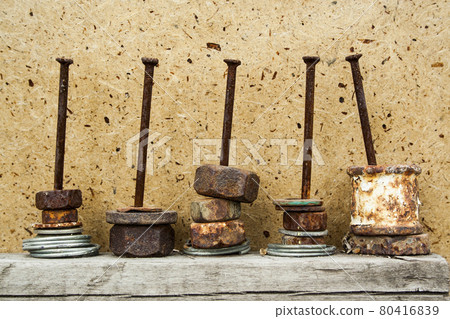 Organized rusty nuts on grunge and aged nails on wooden background. Concept of work, construction 80416839