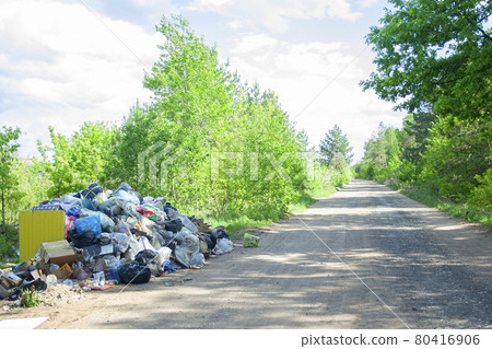 Illegal dump near the country sand road in the country on sunny day. Trash pollution in the nature. Dirty dump near woods Illegal dump near the country sand road in the country on sunny day. Trash pollution in the nature. Dirty dump near woods 80416906