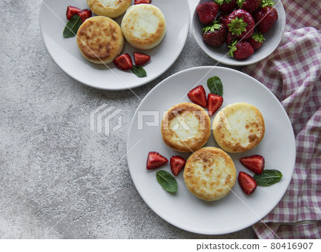 Cottage cheese pancakes, ricotta fritters on ceramic plate with  fresh strawberry. 80416907
