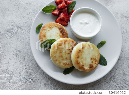Cottage cheese pancakes, ricotta fritters on ceramic plate with fresh strawberry. Cottage cheese pancakes, ricotta fritters on ceramic plate with fresh strawberry. 80416912