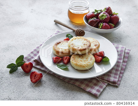 Cottage cheese pancakes, ricotta fritters on ceramic plate with  fresh strawberry. 80416914