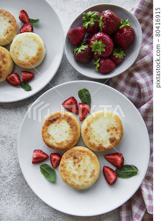 Cottage cheese pancakes, ricotta fritters on ceramic plate with fresh strawberry. Cottage cheese pancakes, ricotta fritters on ceramic plate with fresh strawberry. 80416915