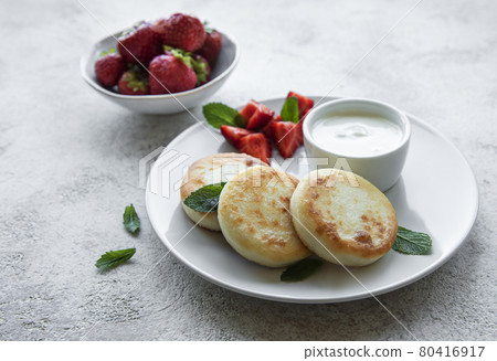 Cottage cheese pancakes, ricotta fritters on ceramic plate with fresh strawberry. Cottage cheese pancakes, ricotta fritters on ceramic plate with fresh strawberry. 80416917