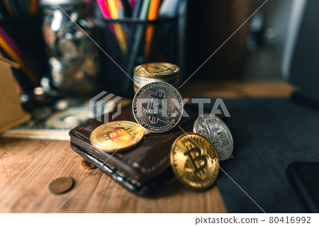 Bitcoin coins on a wooden desk Bitcoin coins on a wooden desk 80416992