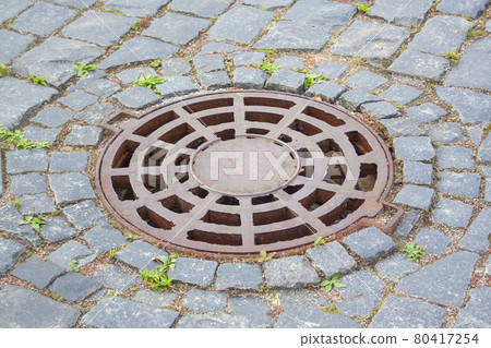 Manhole cover near paving stones Manhole cover near paving stones 80417254