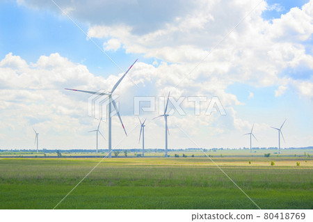 Many big and high windmills at sunny day on the green field. Alternative energy generators. Wind energy. Ecology, save, energy Many big and high windmills at sunny day on the green field. Alternative energy generators. Wind energy. Ecology, save, energy 80418769