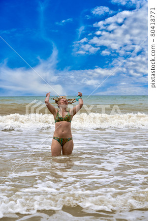 A woman in a swimsuit with white long hair comes out of the sea 80418771