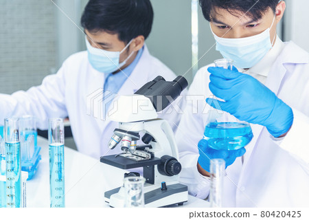 Scientist man look into Microscope research in science laboratory. Asian scientist looking equipment laboratory chemistry labs. Covid-19 coronavirus biochemistry research experiment vaccine concept Scientist man look into Microscope research in science laboratory. Asian scientist looking equipment laboratory chemistry labs. Covid-19 coronavirus biochemistry research experiment vaccine concept 80420425