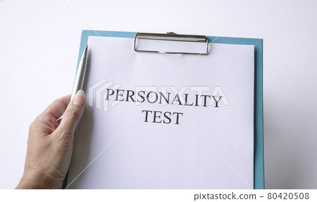 Woman holding a pen with personality test. 80420508