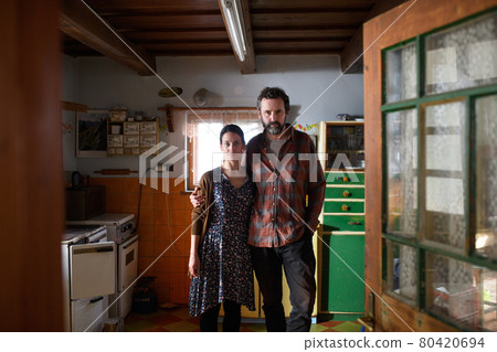 Portrait of sad poor mature couple indoors at home, poverty concept. Portrait of sad poor mature couple indoors at home, poverty concept. 80420694