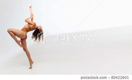 One young beautiful tanned caucasian woman in mustard underwear posing over white background. Flyer 80422601