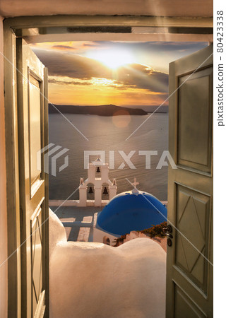 Santorini view with traditional church against colorful sunset in Thira town, Greece 80423338