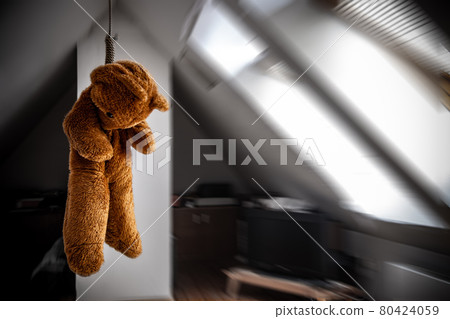 A teddy bear hanging in a noose in the attic room A teddy bear hanging in a noose in the attic room 80424059