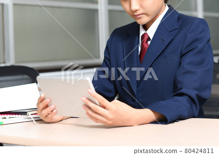 Female student operating a tablet Female student operating a tablet 80424811