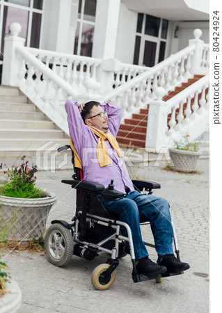 a man with disabilities in a wheelchair talking on a smartphone a man with disabilities in a wheelchair talking on a smartphone 80424924