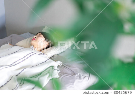 Young woman sleeping soundly in bed 80425679