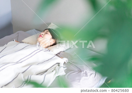 Young woman sleeping soundly in bed 80425680