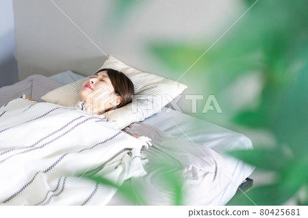 Young woman sleeping soundly in bed 80425681