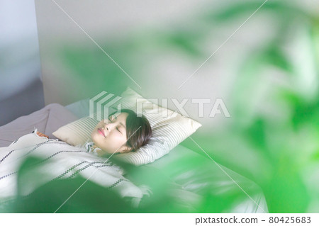 Young woman sleeping soundly in bed Young woman sleeping soundly in bed 80425683