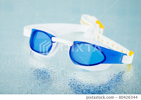 professional swimming glasses for training or competition, blue background professional swimming glasses for training or competition, blue background 80426344