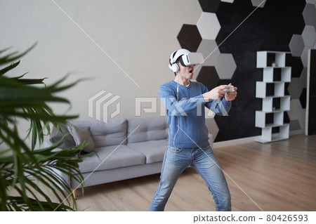 Man with virtual reality headset is playing game. 80426593