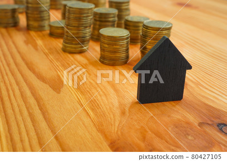 Small house and stacks of coins as a symbol of mortgage and loans. Small house and stacks of coins as a symbol of mortgage and loans. 80427105