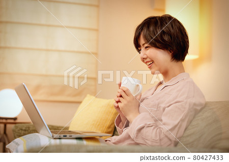 年輕女子在沙發上看電腦 年輕女子在沙發上看電腦 80427433