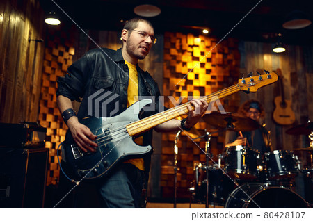 Brutal musician with electric guitar on stage Brutal musician with electric guitar on stage 80428107