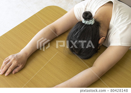 A woman who is tired and lays down on the table (Japanese, 30s) 80428148