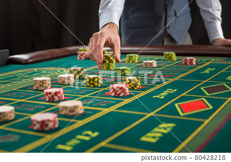 Picture of a green table and betting with chips. 80428218