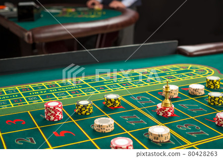 Picture of a green table and betting with chips. 80428263