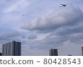A passenger plane flying low over the city to land at Haneda Airport 80428543