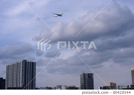 A passenger plane flying low over the city to land at Haneda Airport A passenger plane flying low over the city to land at Haneda Airport 80428544