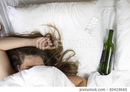 Sleeping drunk girl with empty wine bottle. Lying on the bed fainted, alcohol abuse,addiction concept top view Sleeping drunk girl with empty wine bottle. Lying on the bed fainted, alcohol abuse,addiction concept top view 80428688