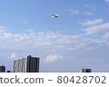 A passenger plane flying low over the city to land at Haneda Airport 80428702