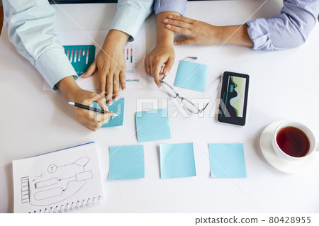 High angle view of female hands during working day, business meeting. Using laptop, modern gadgets, notes. Workplace at office with PC, devices. 80428955