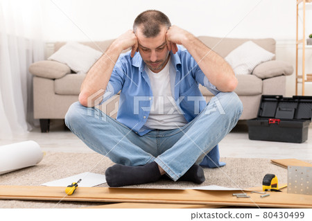 Confused Man Having Hard Time Assembling Furniture Reading Manual Indoor 80430499
