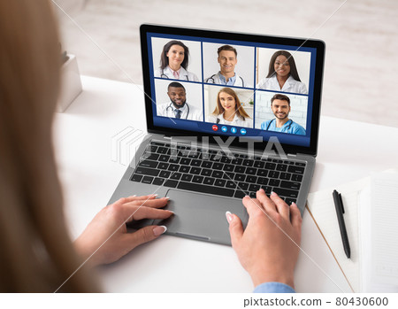 Lady Doctor At Laptop Video Calling Diverse Colleagues Indoors, Back-View 80430600