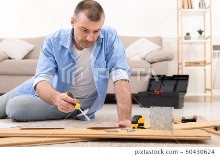 Man Fixing Wooden Cabinet Using Screwdriver And Carpentry Tools Indoor Man Fixing Wooden Cabinet Using Screwdriver And Carpentry Tools Indoor 80430624