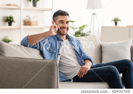 Portrait of smiling israeli man talking on phone at home 80430709