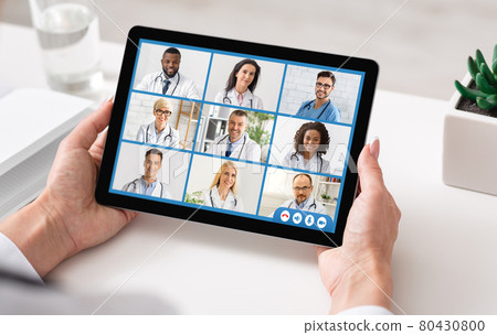 Doctor Lady Making Video Call With Colleagues Using Tablet Indoor Doctor Lady Making Video Call With Colleagues Using Tablet Indoor 80430800