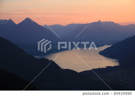 Red evening sky over Lake Thun and mountain ranges in Switzerland. Red evening sky over Lake Thun and mountain ranges in Switzerland. 80430990