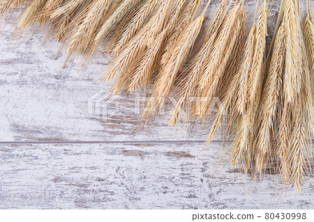 Close-up top view wheat spikelets on white wood background. 80430998