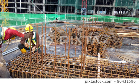 KUALA LUMPUR, MALAYSIA -JANUARY 14, 2017: Construction workers fabricating steel reinforcement bar at the construction site. The reinforcement bar was tied together using tiny wire.     80431596