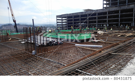 KUALA LUMPUR, MALAYSIA -NOVEMBER 23, 2020: Building floor slab under construction. Construction workers fabricating the timber formwork and installing the steel reinforcement bar. KUALA LUMPUR, MALAYSIA -NOVEMBER 23, 2020: Building floor slab under construction. Construction workers fabricating the timber formwork and installing the steel reinforcement bar. 80431875