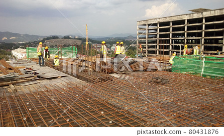 KUALA LUMPUR, MALAYSIA -NOVEMBER 23, 2020: Building floor slab under construction. Construction workers fabricating the timber formwork and installing the steel reinforcement bar. KUALA LUMPUR, MALAYSIA -NOVEMBER 23, 2020: Building floor slab under construction. Construction workers fabricating the timber formwork and installing the steel reinforcement bar. 80431876