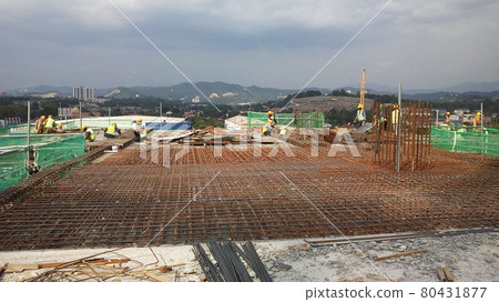 KUALA LUMPUR, MALAYSIA -NOVEMBER 23, 2020: Building floor slab under construction. Construction workers fabricating the timber formwork and installing the steel reinforcement bar. KUALA LUMPUR, MALAYSIA -NOVEMBER 23, 2020: Building floor slab under construction. Construction workers fabricating the timber formwork and installing the steel reinforcement bar. 80431877