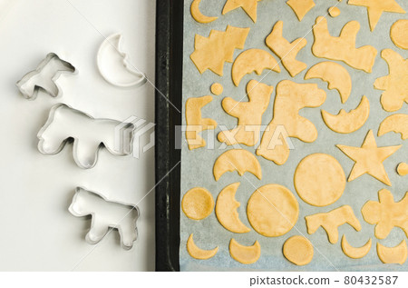 Christmas cookie cutter shapes and raw dough Christmas cookie cutter shapes and raw dough 80432587