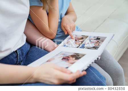top view. mother and daughter watch photobook from discharge of newborn baby 80432838