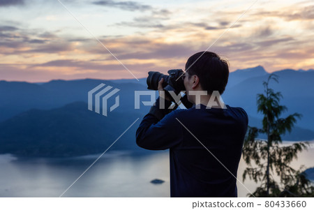 Adventure Photographer Hiking and taking pictures of Canadian mountain landscape 80433660